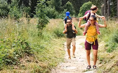 Family with small children hiking outdoors in summer nature. How Can Health Screening Protect You And Your Family?