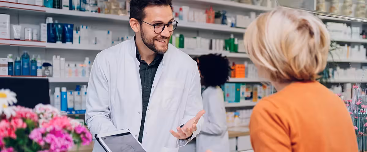 Portrait of a male pharmacist working at the counter in pharmacy. Antibiotics in the UK: Access and Prescription Guidelines