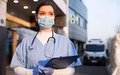 NHS Doctor Looking at paperwork about patient. Is The NHS Being Privatised?
