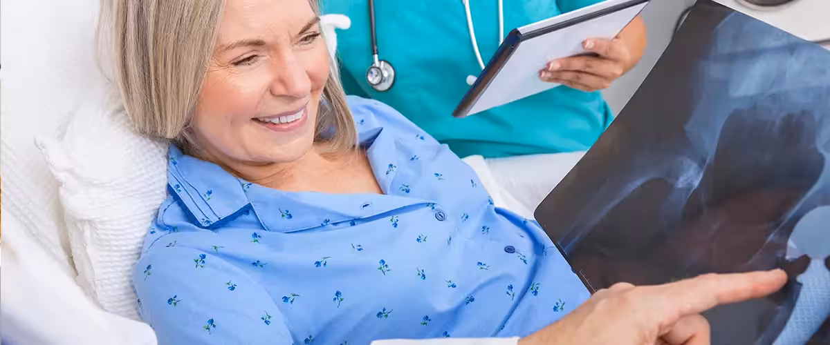 Woman who has recently had a hip operation being assisted by a nurse. Cost private hip replacement UK.