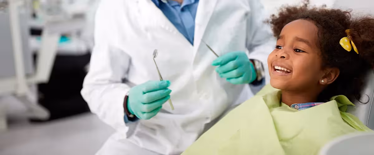 Happy child during a dentist appointment. When should I take my child to the dentist?