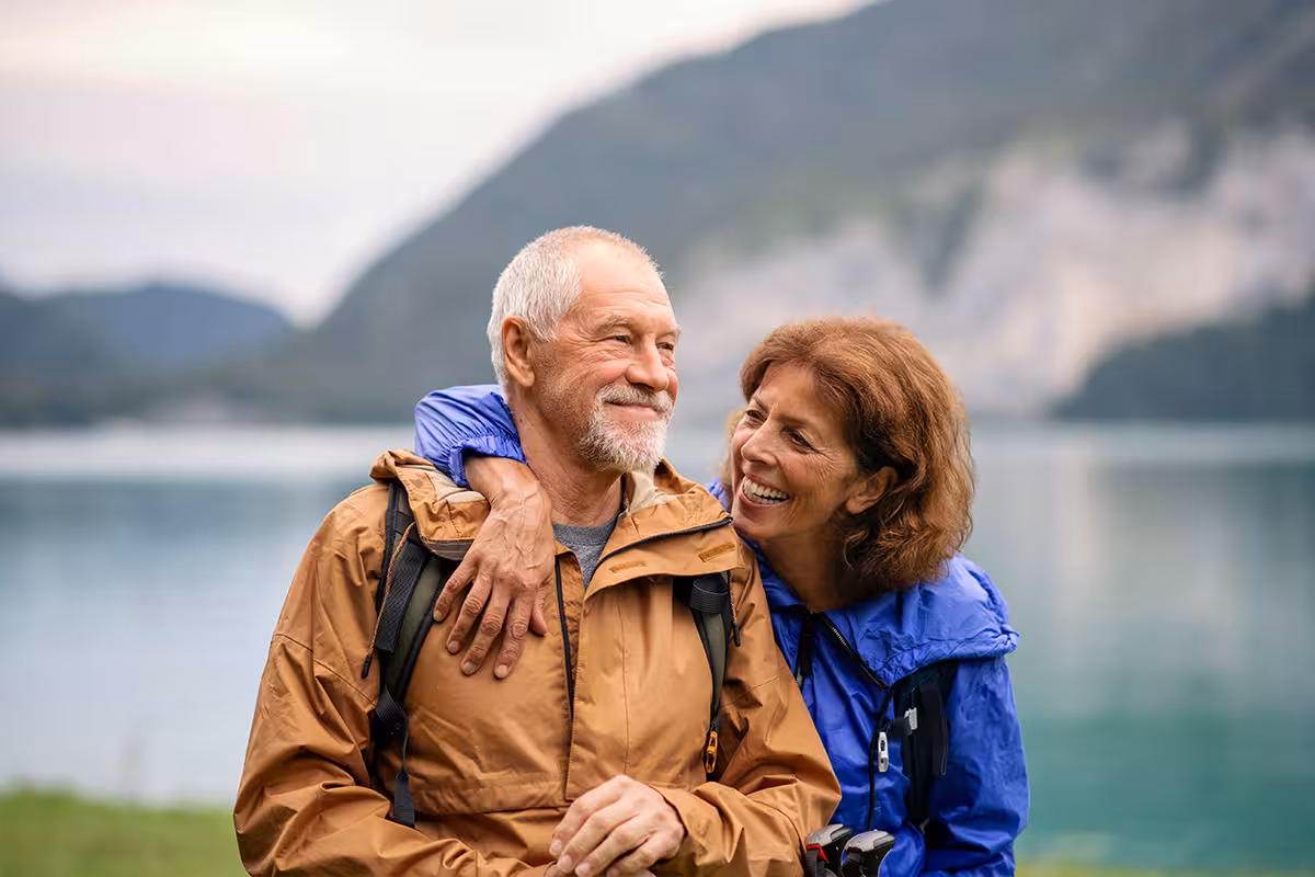 Senior pensioner couple hiking by lake in nature, resting. How Does Life Insurance Work In The UK?