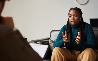 Women sitting on sofa and discussing her mental health problems with psychologist during a therapy session. Does Health Insurance Cover Therapy? 