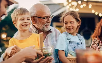 Happy Senior Grandfather Talking and Having Fun with His Grandchildren. Guide To The Best Over 70s Private Health Insurance (UK)
