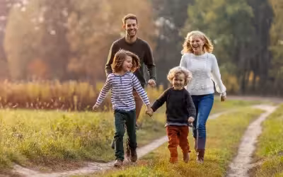 family with 2 young children walking down country path, trees behind, Autumn. Exploring UK Private Mental Health Cover: Vitality