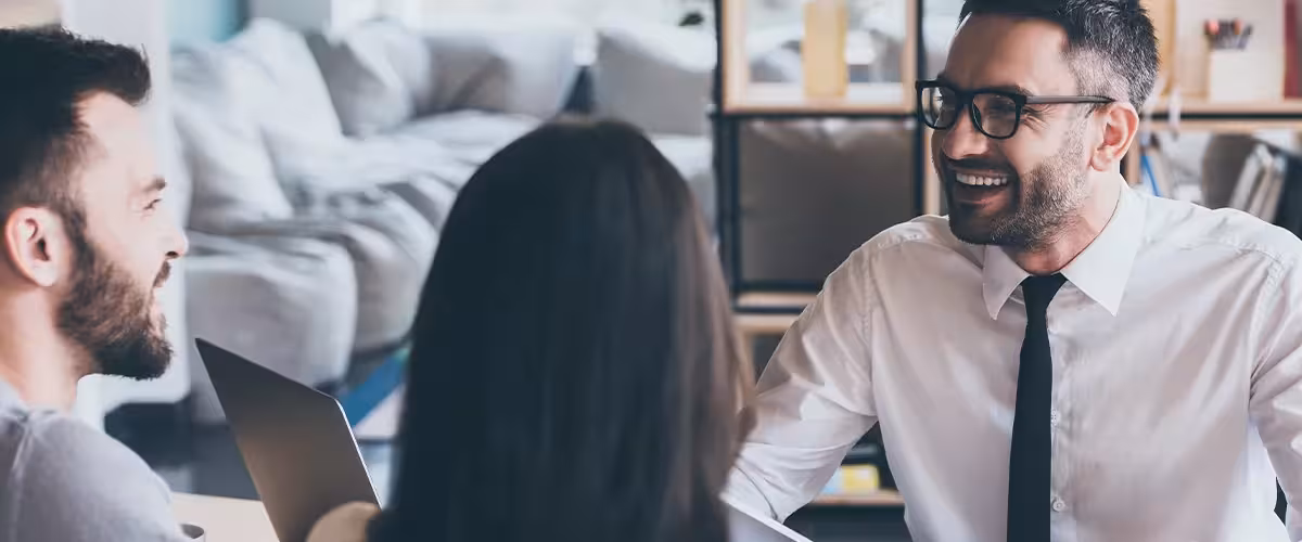 Smiling insurance broker giving advice to young couple. Is Health Insurance More Expensive Via A Broker?