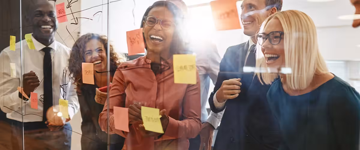 Laughing businesspeople having a brainstorming session about how to improve their mental health at work.