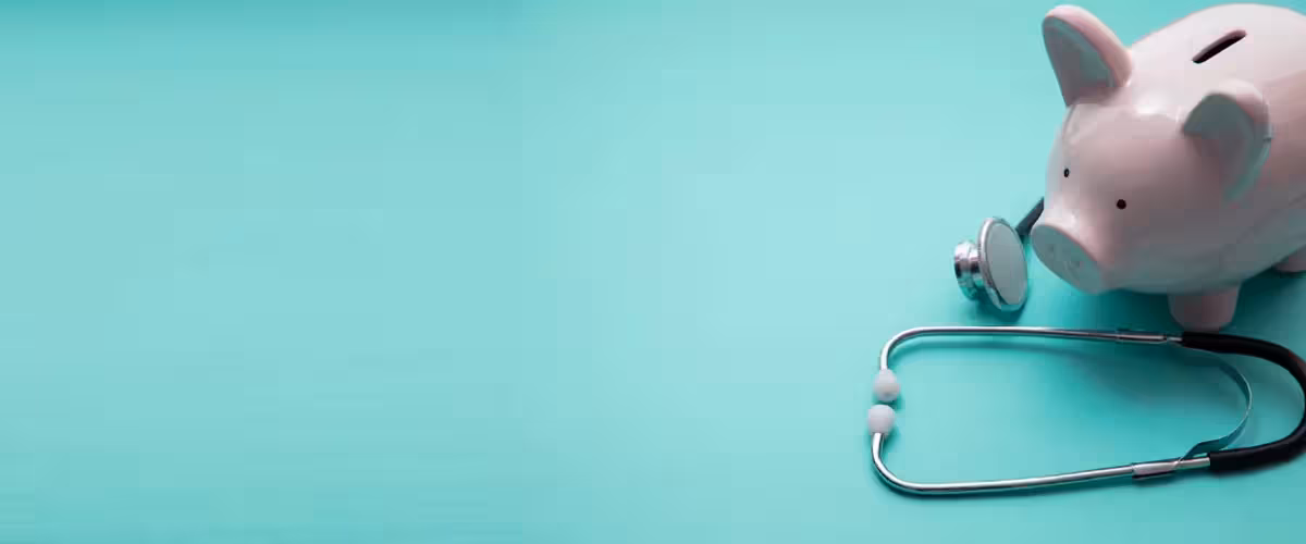Cost of private Health Insurance in comparison with Health cash plans. Piggy bank money box with a medical doctors stethoscope.