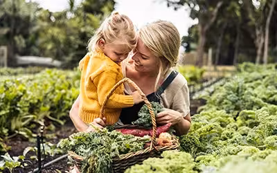 Healthy mother and daughter laughing in field. When Is It Worth Paying More For Health Insurance?