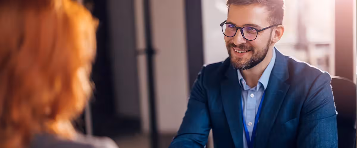 Happy insurance broker shaking hands with a client after successfully finding the best policy for them. 