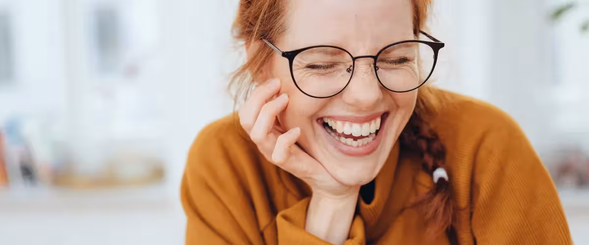 Smiling woman with glasses and white teeth