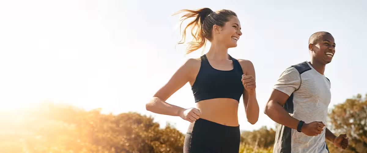 Healthy, happy couple running on the road in the countryside. 9 Tips When Comparing Health Insurance In The UK - 2025