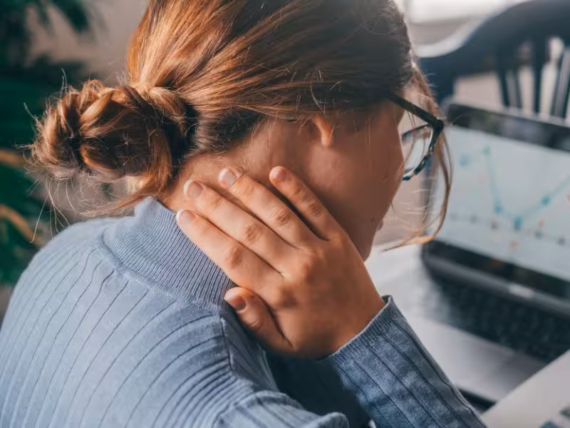 Young woman holding her neck feeling pain