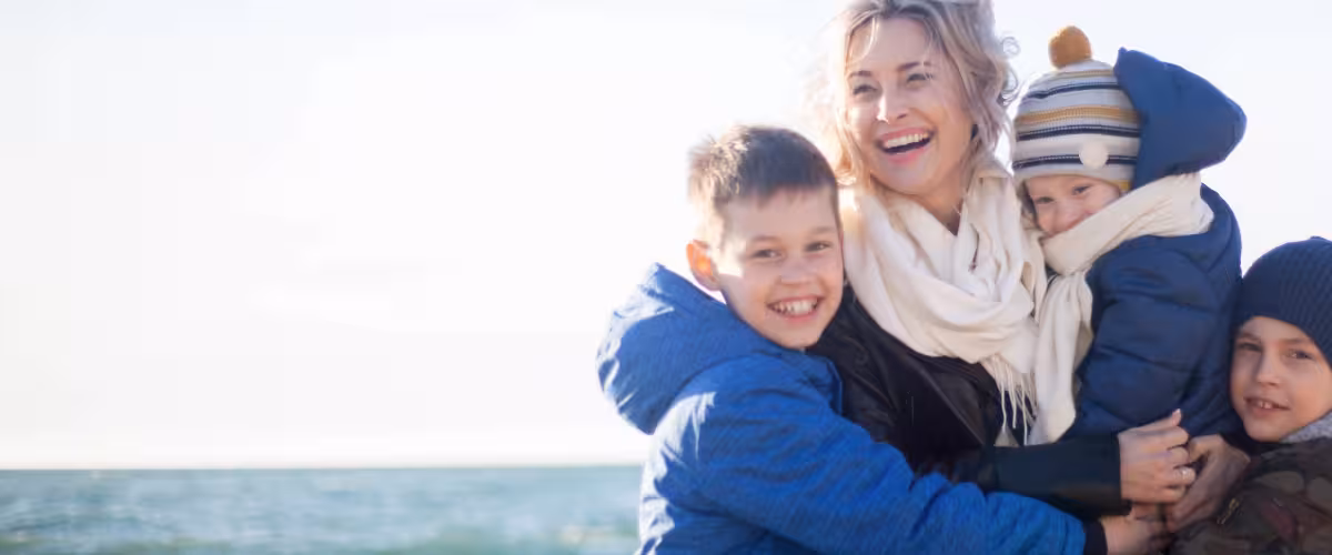 Mother and her three sons enjoying the beach in winter. Life insurance and trusts.