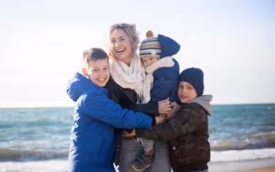Mother and her three sons enjoying the beach in winter. Life insurance and trusts.