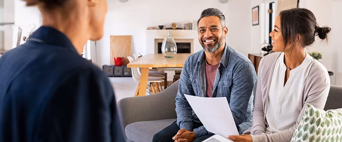 Couple asking a health insurance broker questions.