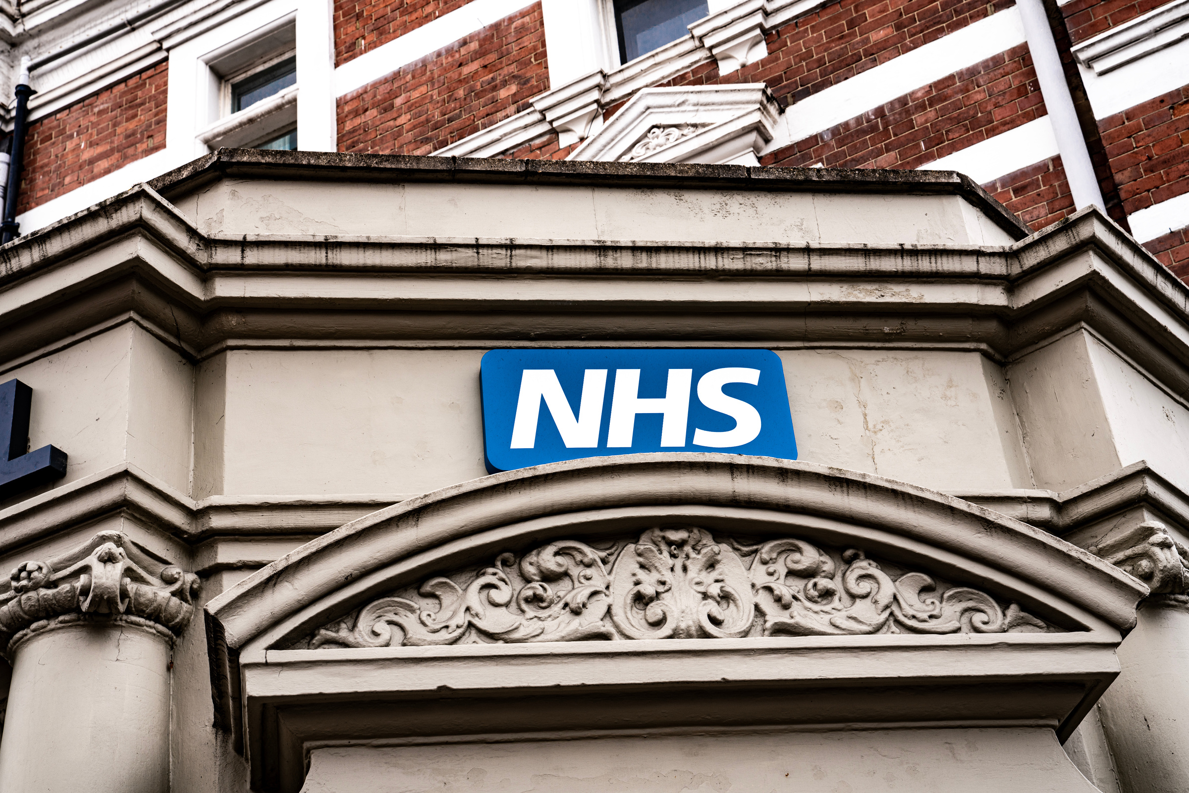 Exterior of a UK NHS GP practice building showing the NHS signage