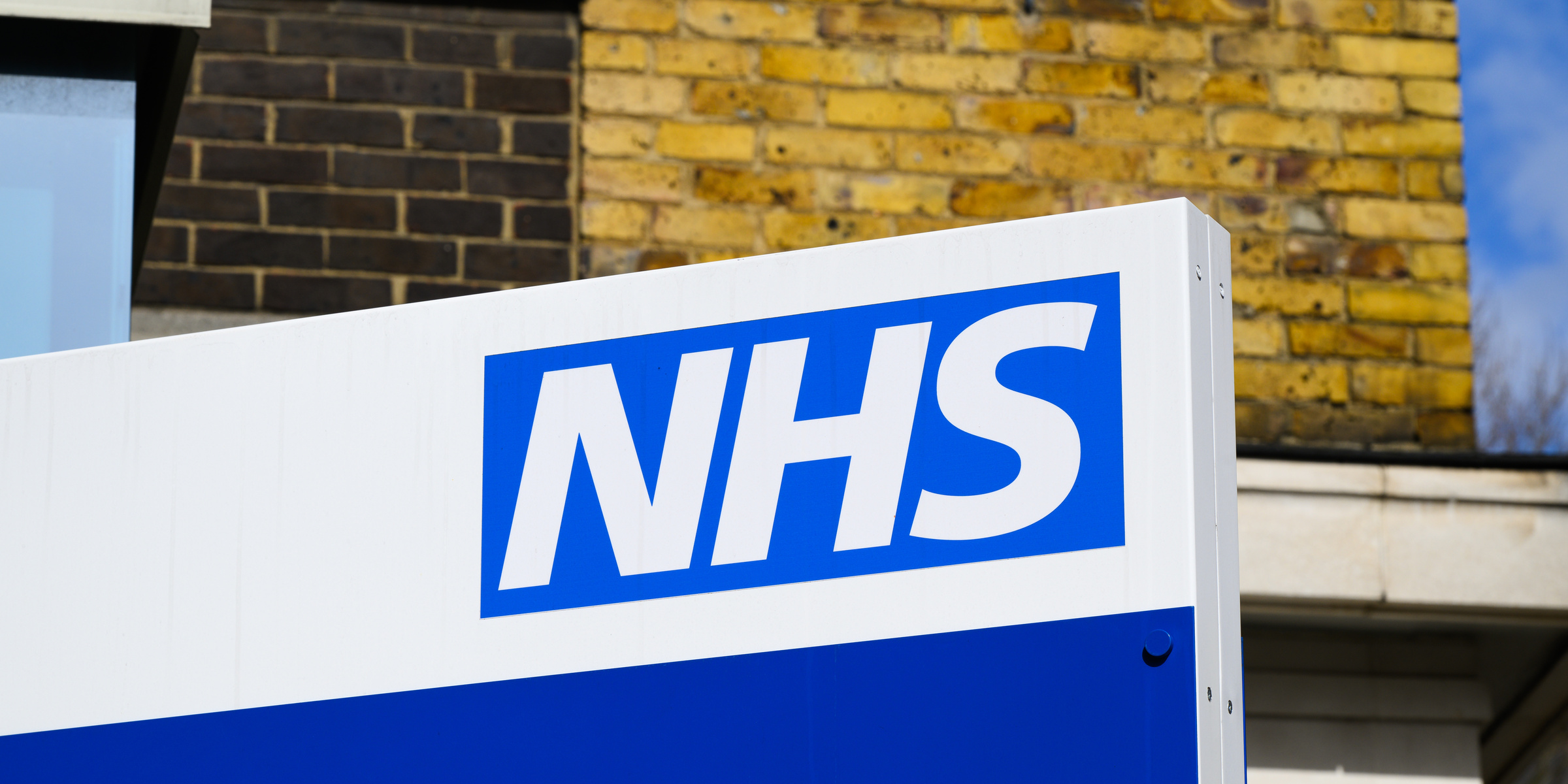 NHS hospital building exterior alongside a private healthcare clinic in the UK