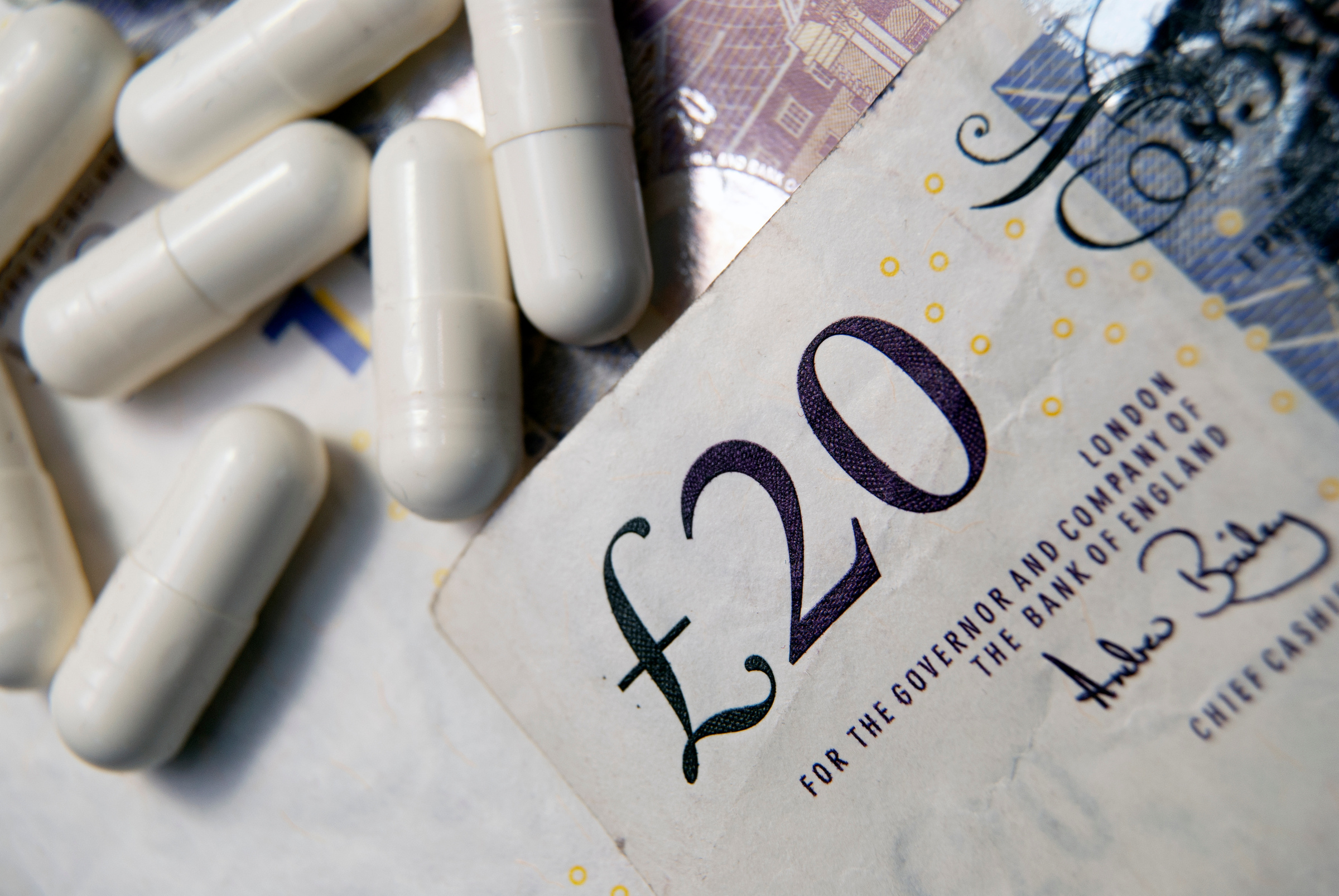 Pharmacist preparing a private prescription for a patient at a UK pharmacy counter