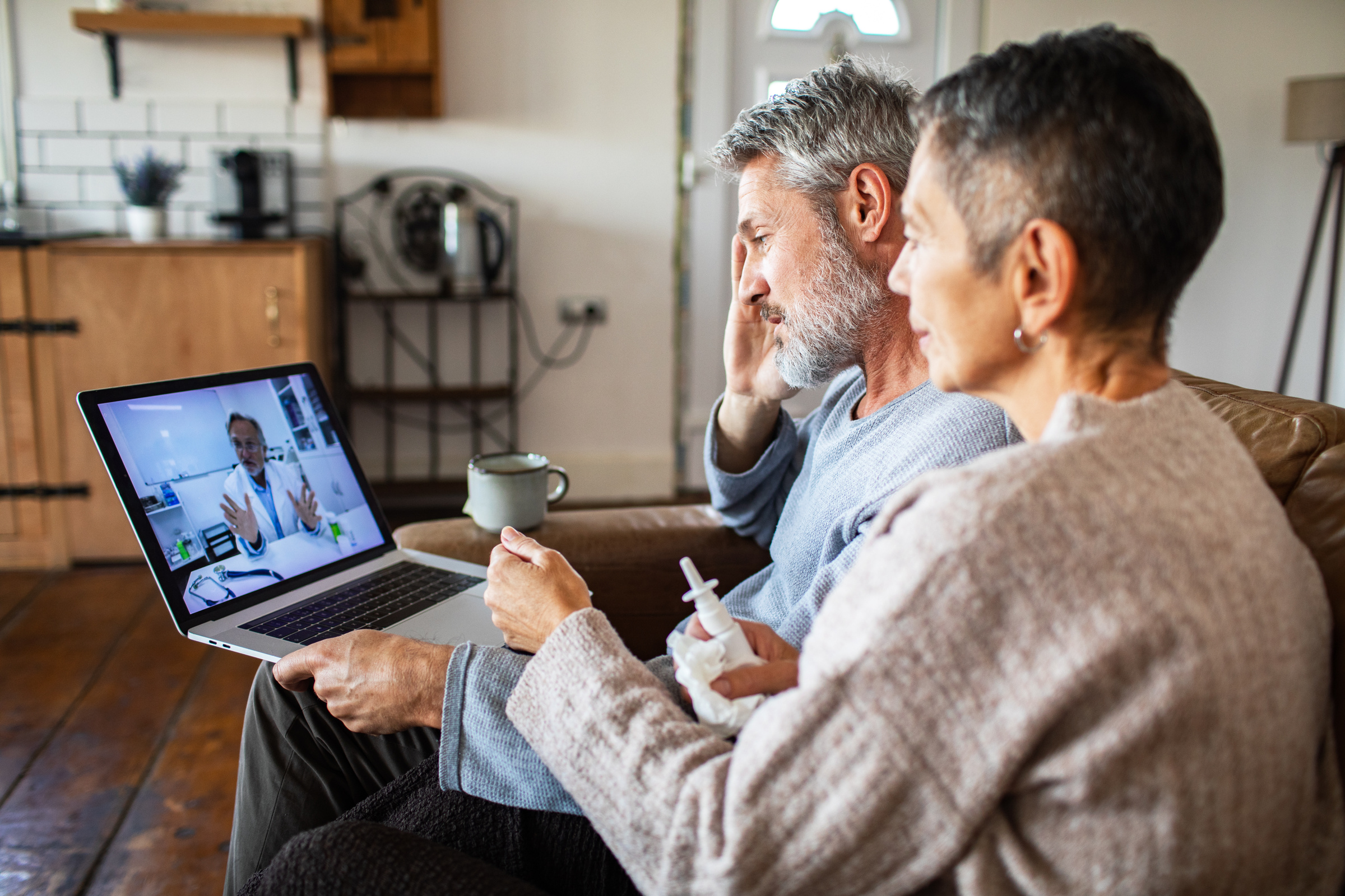 Patient consulting a GP through a video call on a laptop at home in the UK