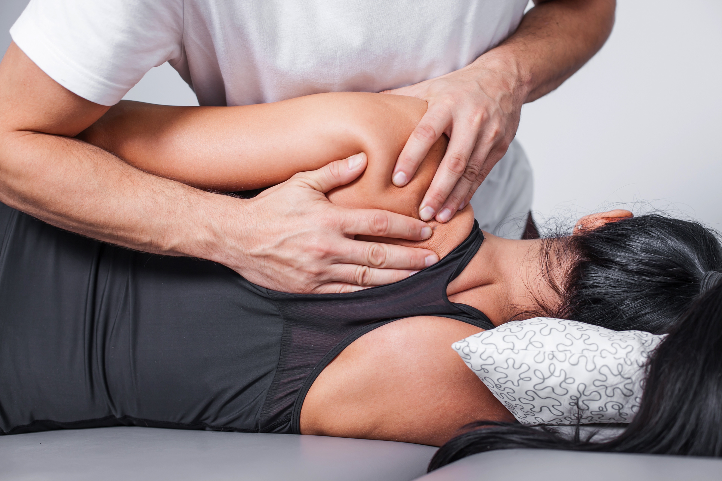 Physiotherapist treating a patient's back during a private physiotherapy session at a UK clinic
