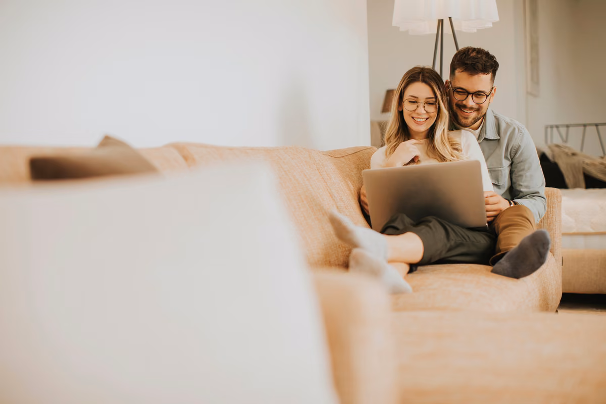 Couple comparing the best UK life insurance providers on a laptop at home