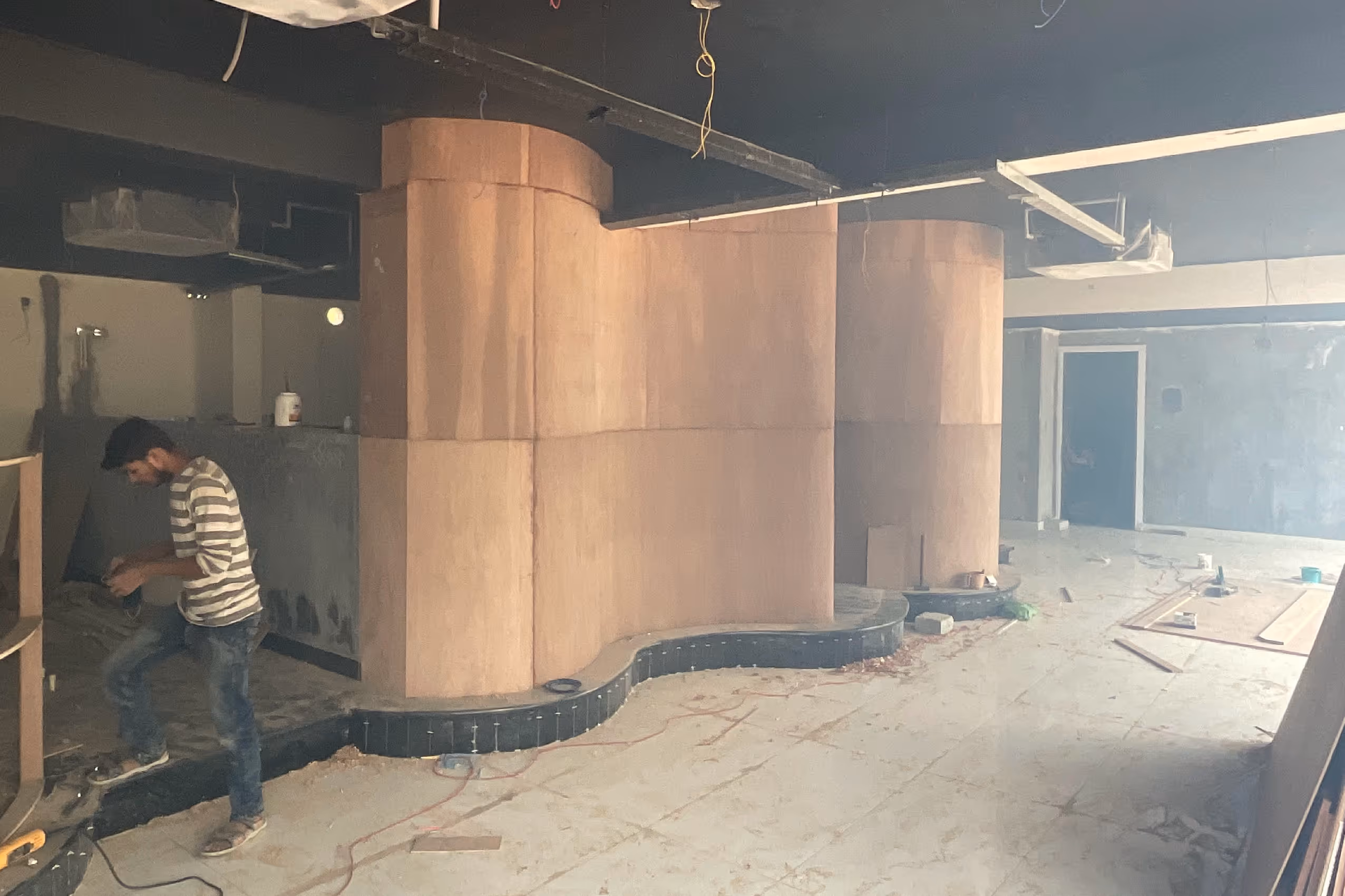 bent plywood partition walls with saw dust in the air