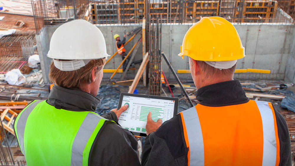 two construction workers looking at tablet
