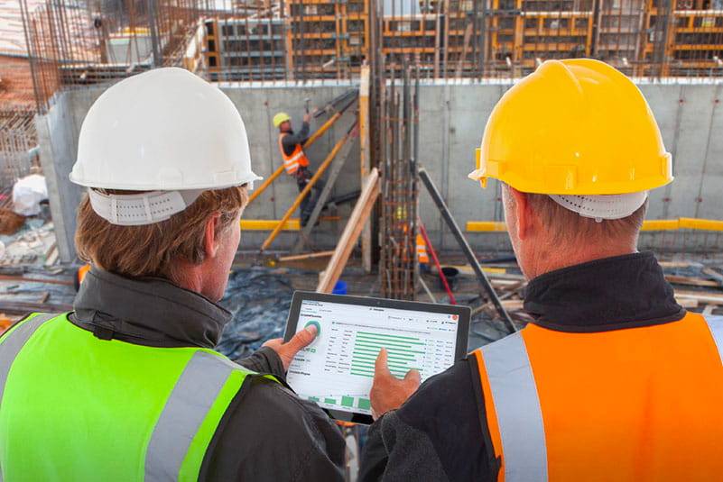 two construction workers looking at tablet