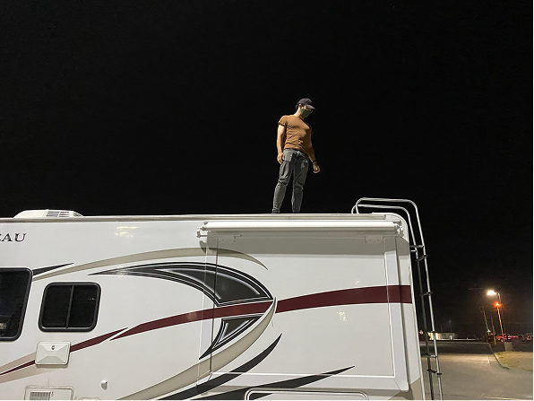 John on the roof of the RV at night