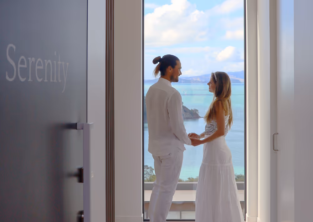 A couple at Villa Serenity with an ocean view behind them