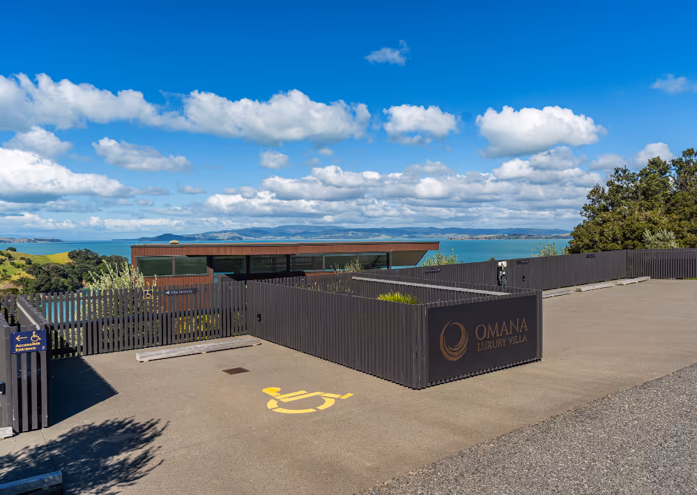 Omana boutique hotel's car park with an ocean view in the back
