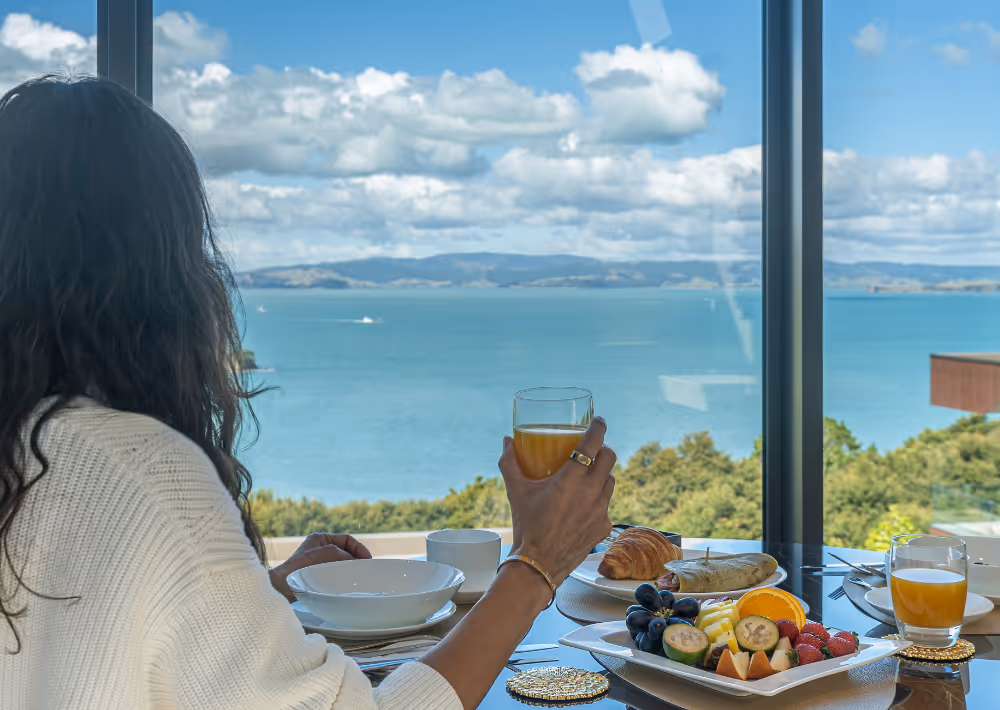 A guest having breakfast at Omana with stunning ocean view in the backdrop