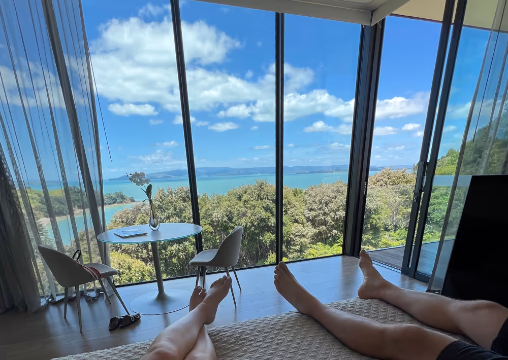 A couple lying on bed with the ocean view as their backdrop