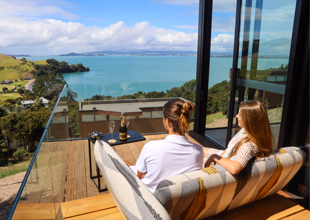 A couple sitting on Villa Serenity's balcony marvels at the ocean view