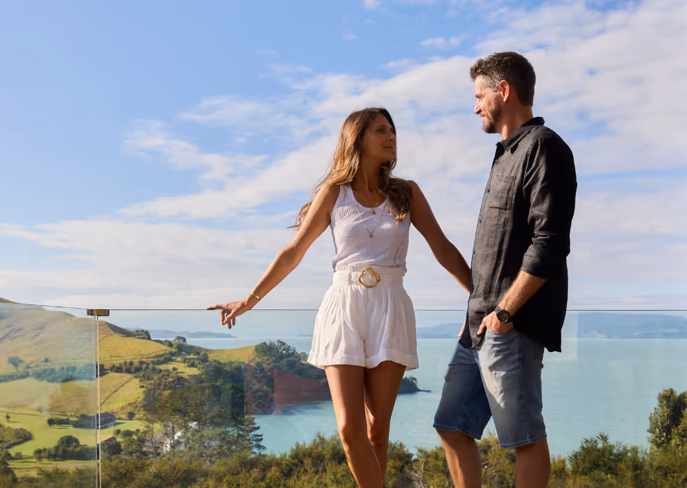 A couple on Omana villas balcony with the ocean in the backdrop