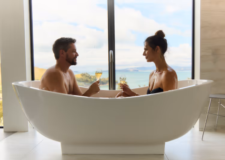 Omana guests enjoy a bath with an ocean view and sparkling wine