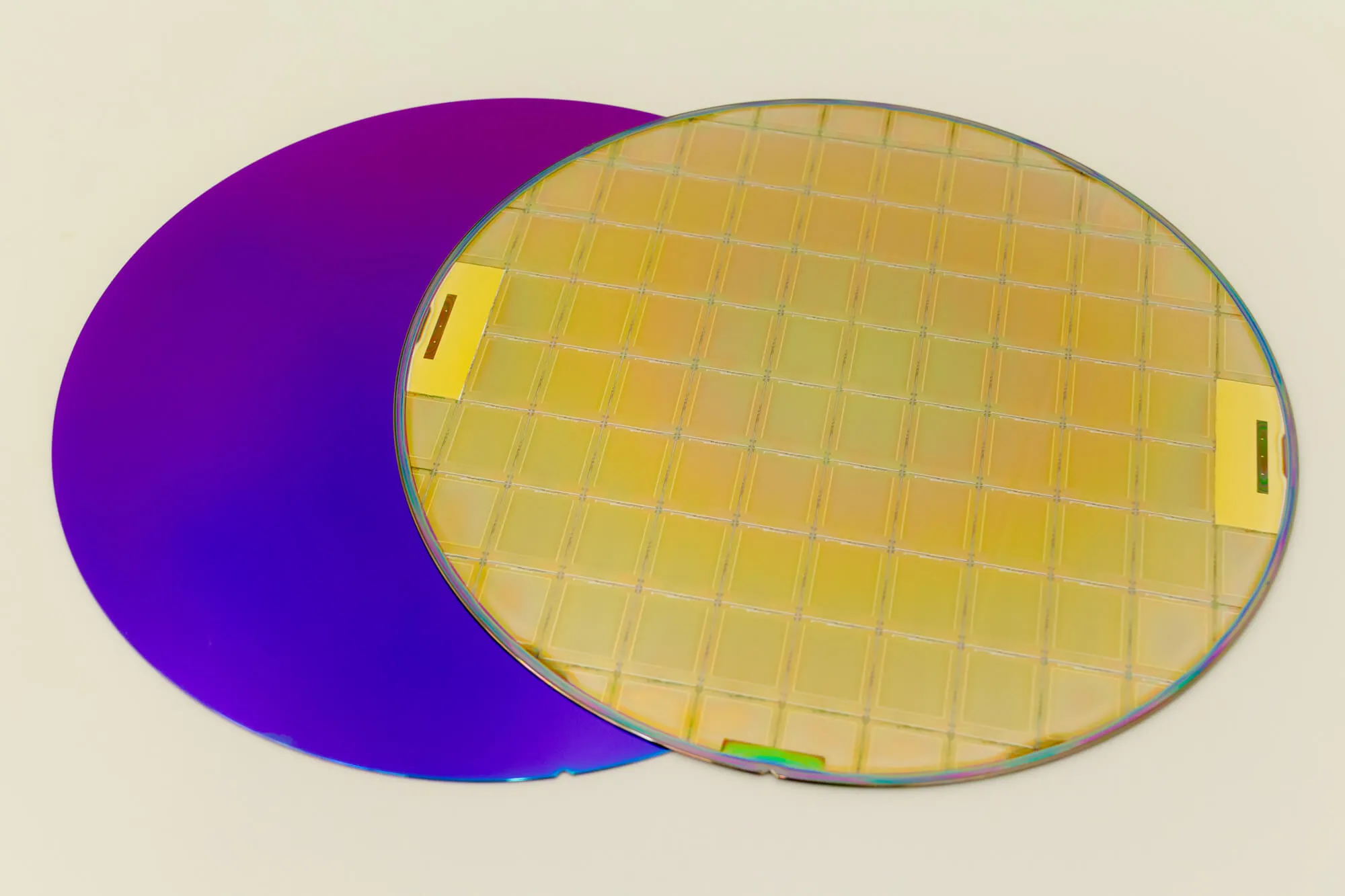 Two wafers on a white surface at a silicon wafer manufacturer place