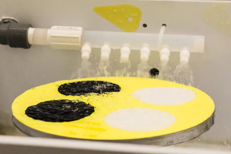 silicon-wafer-with-etched-patches-being-rinsed-under-water-jets