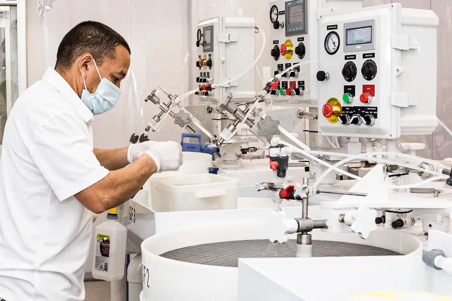 silicon-wafer-suppliers-worker-adjusting-wafer-lapping-machine-controls