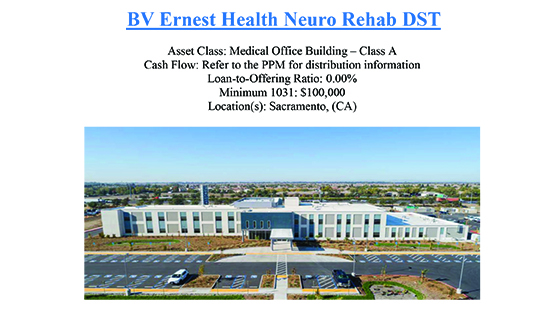 Modern two-story medical office building with parking lot in front under a clear blue sky.
