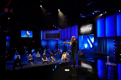 Adam Hunter on stage addressing a crowd