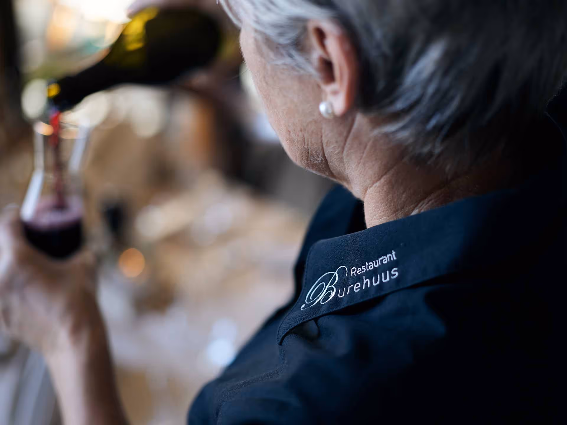 A woman pours a glass of wine