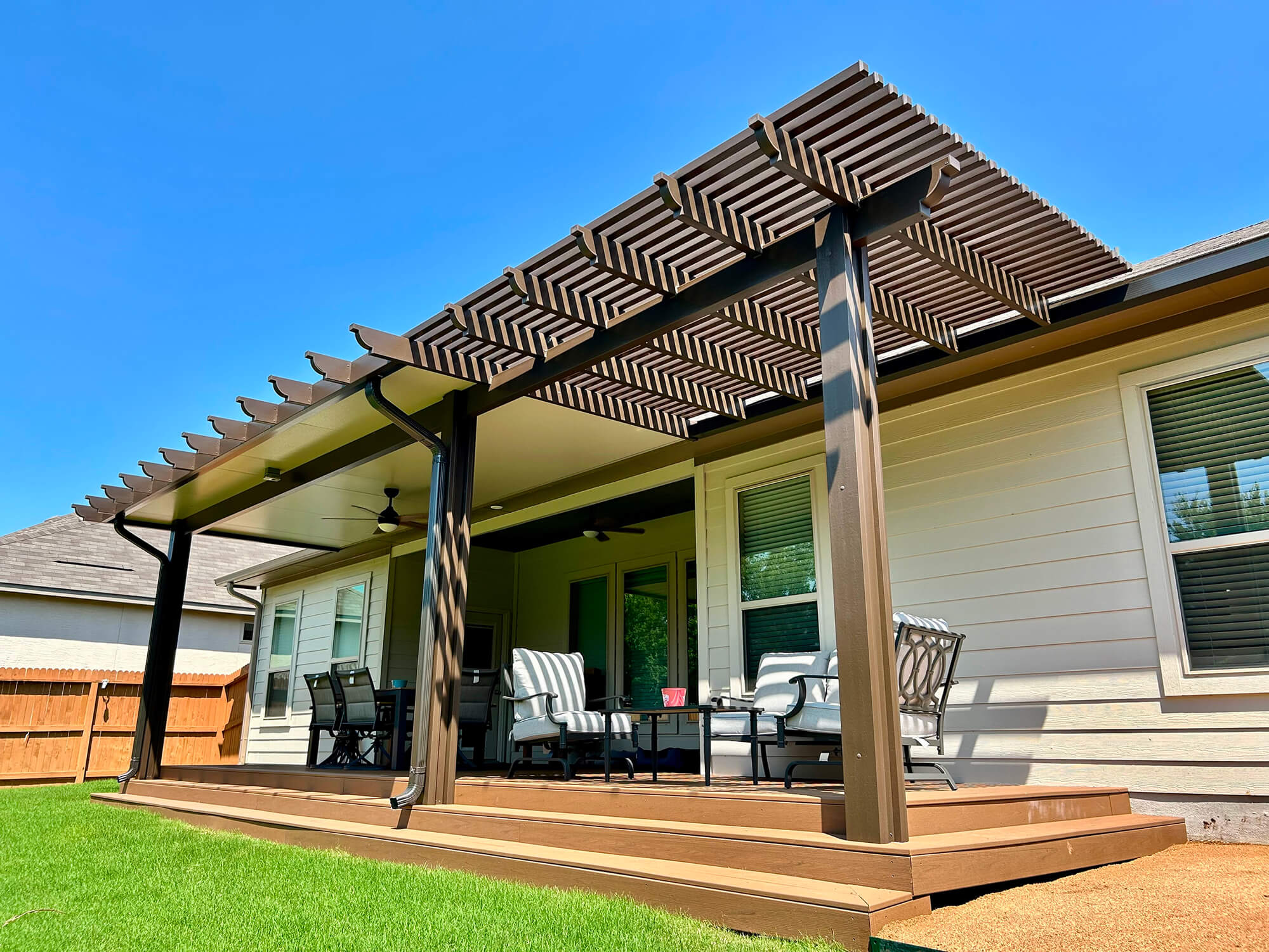 Wood patio cover over seating area in backyard.
