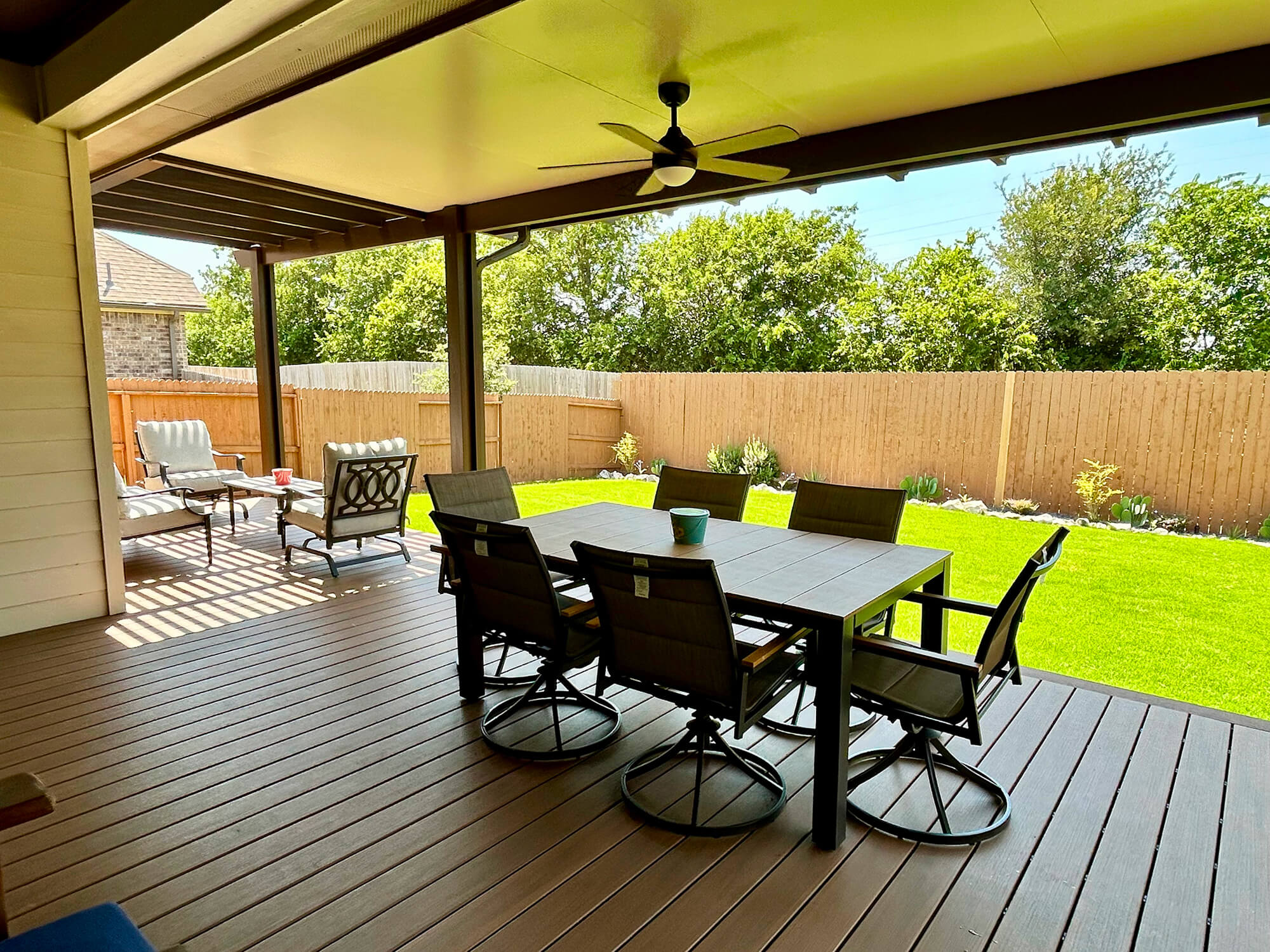 Covered patio with dining table and chairs, San Antonio backyard.