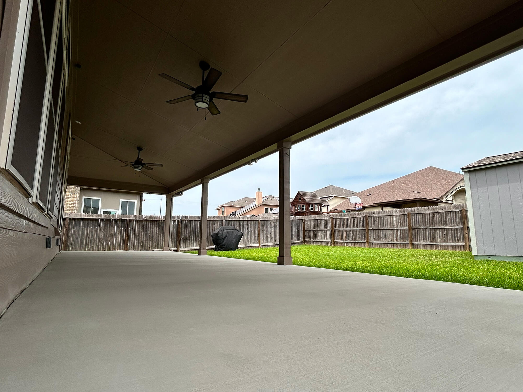 Covered patio in a San Antonio backyard with ceiling fans.