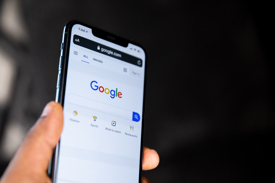 Hand holding phone displaying Google search