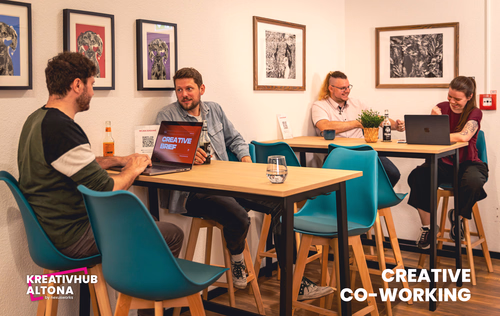 Vier Personen arbeiten gemeinsam in einem modernen Coworking-Space mit bunten Stühlen und Wandbildern.
