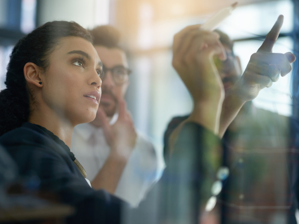 Two professionals collaborating and pointing while discussing ideas in an office setting.