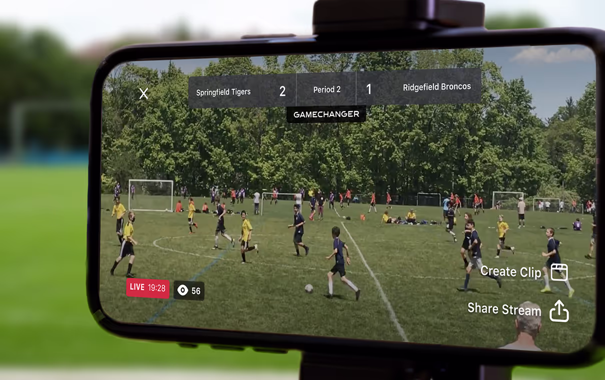Smartphone screen showing live youth soccer game between Springfield Tigers leading 2-1 against Ridgefield Broncos in period 2 with options to create clip or share stream.